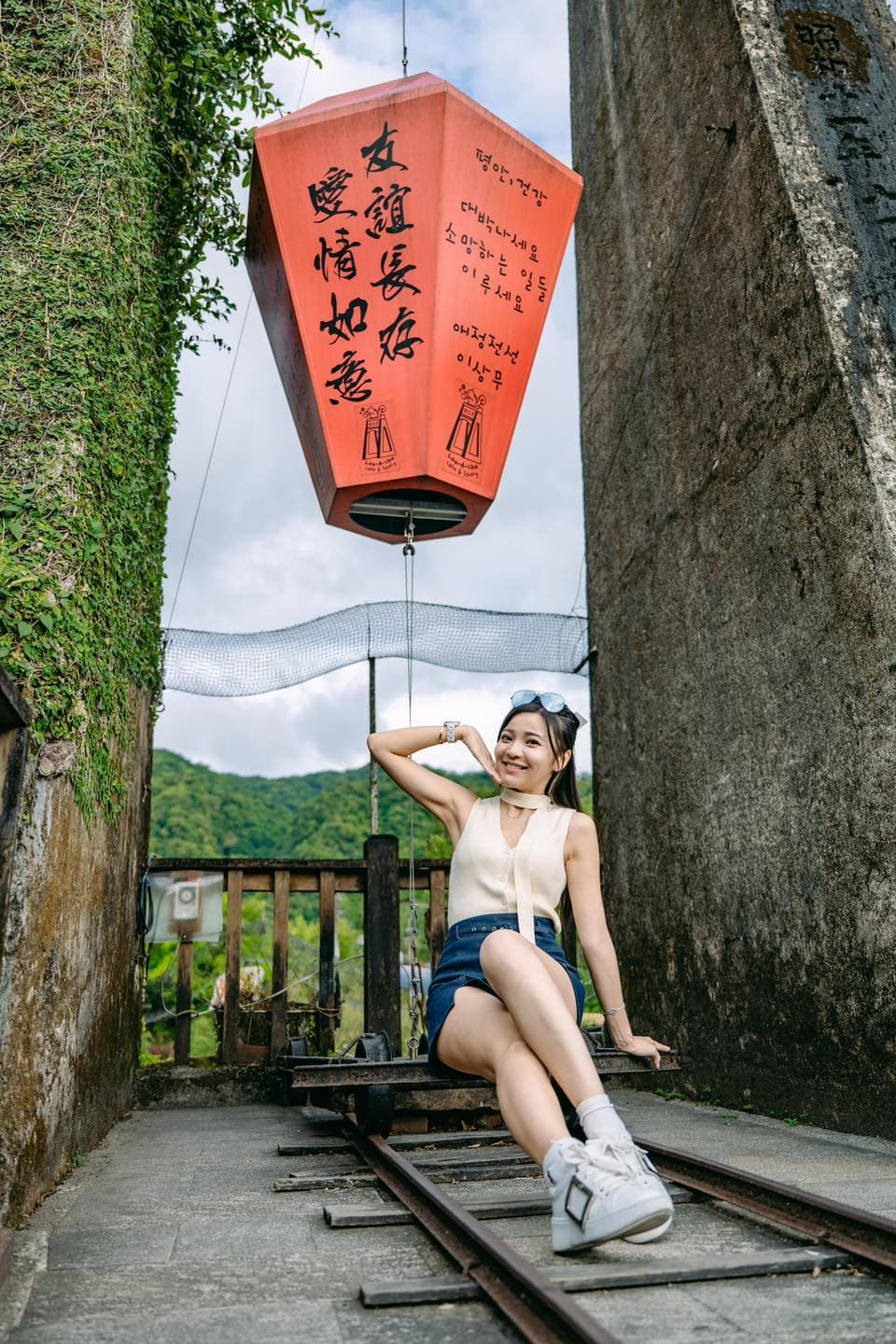 一家三口在海邊沙灘，爸媽牽起小孩跳躍